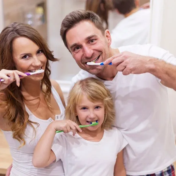 Una famiglia che si lava i denti dopo uno trattamento di Sbiancamento denti